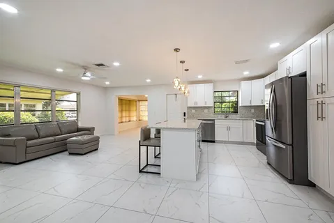 a kitchen with a refrigerator and white cabinets