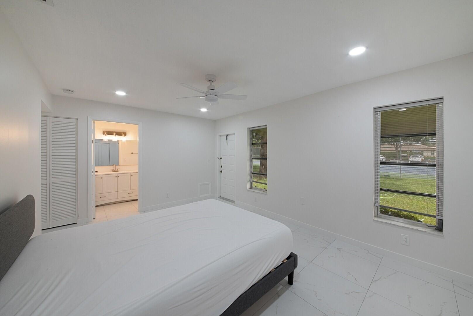 5220 Nesting Way, Unit D Delray Beach, FL 33484 - Photo 20 of 29 a bedroom with a bed and a window