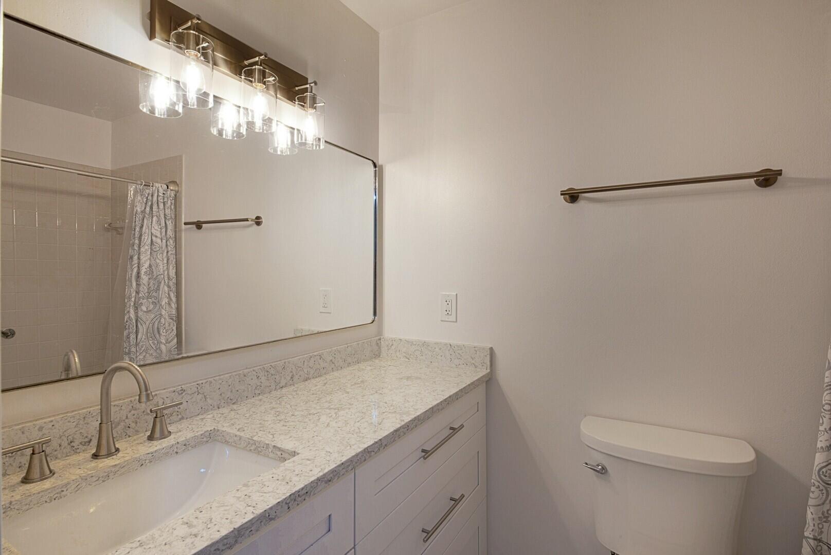 5220 Nesting Way, Unit D Delray Beach, FL 33484 - Photo 23 of 29 a bathroom with a granite countertop sink a toilet and a mirror