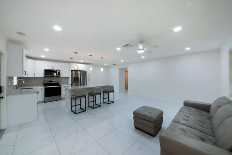 a living room with furniture and kitchen view
