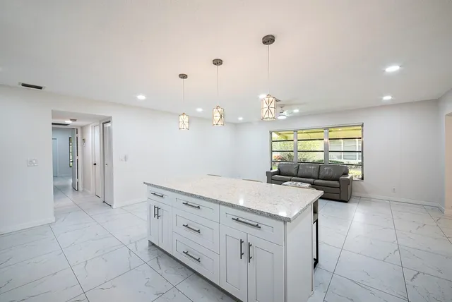 a kitchen with granite countertop a sink and a stove top oven