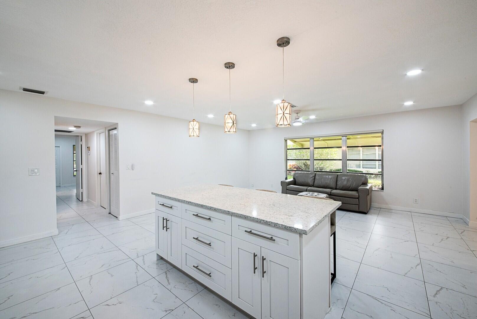 5220 Nesting Way, Unit D Delray Beach, FL 33484 - Photo 9 of 29 a kitchen with granite countertop a sink and a stove top oven
