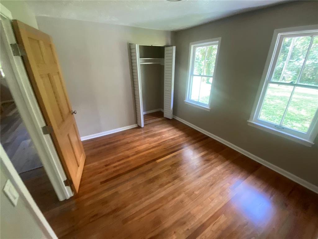 3023 Southeast 13th Place Gainesville, FL 32641 - Photo 14 of 29 a view of an empty room with wooden floor and a window
