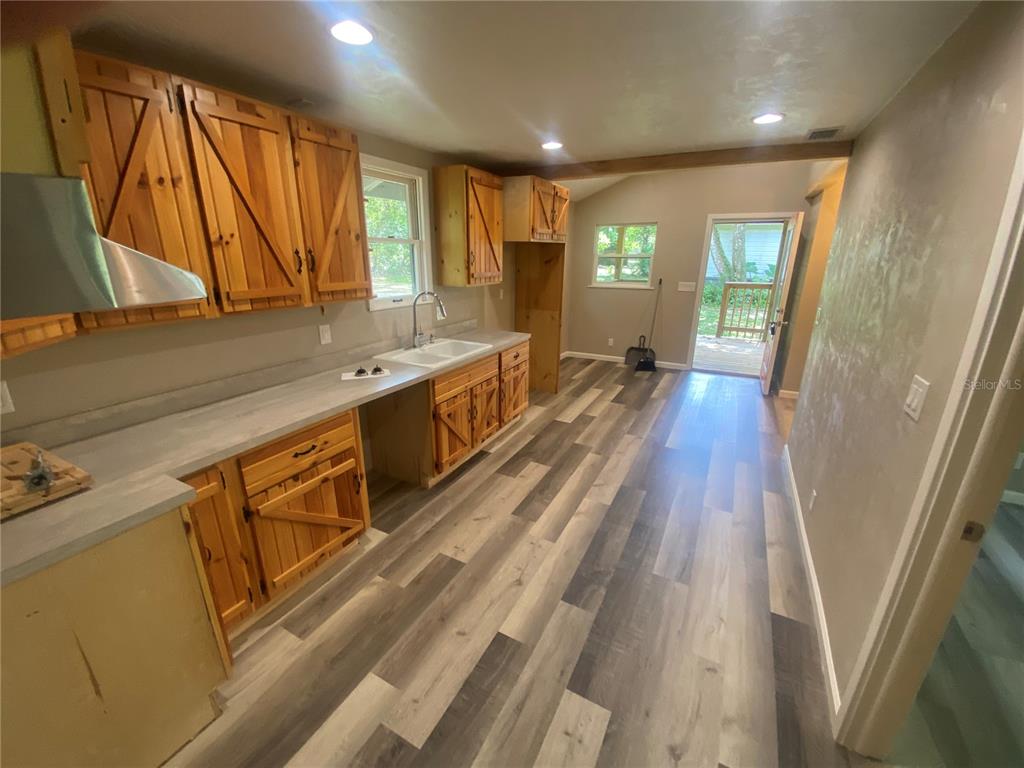 3023 Southeast 13th Place Gainesville, FL 32641 - Photo 18 of 29 a large kitchen with wooden floor and a sink
