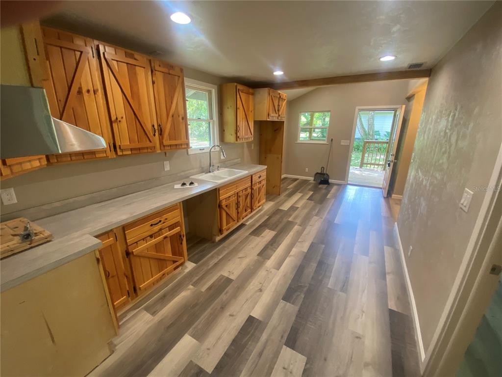 3023 Southeast 13th Place Gainesville, FL 32641 - Photo 19 of 29 a large kitchen with a sink and wooden floor