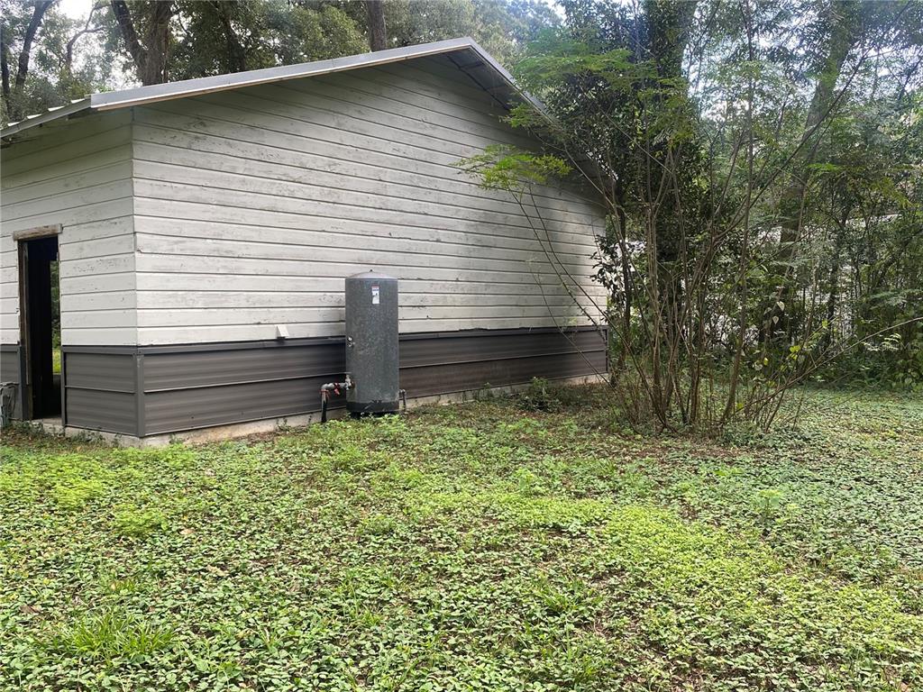 3023 Southeast 13th Place Gainesville, FL 32641 - Photo 24 of 29 a small white house with a small yard and large trees