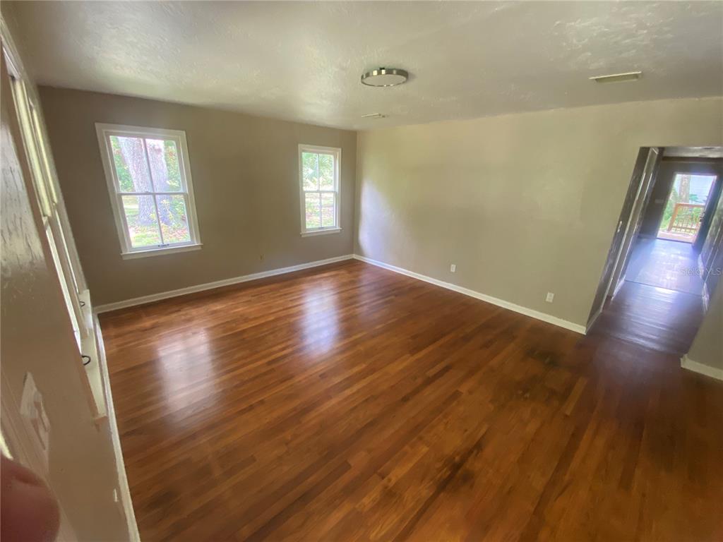 3023 Southeast 13th Place Gainesville, FL 32641 - Photo 9 of 29 a view of an empty room with wooden floor and a window