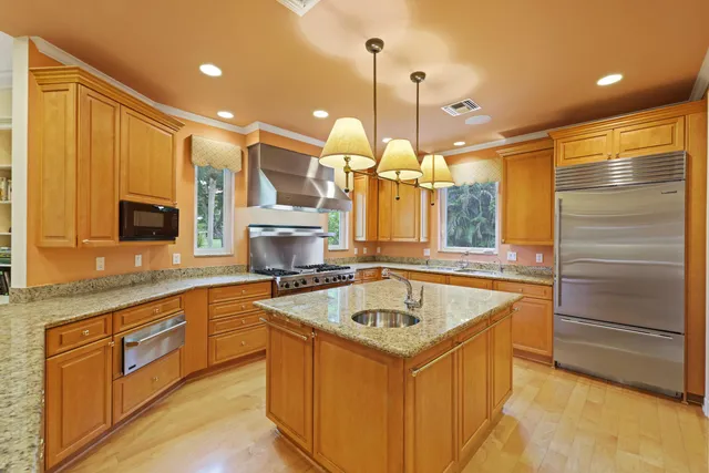 a kitchen with a sink a counter top space appliances and cabinets