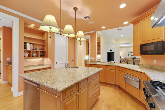 a kitchen with stainless steel appliances granite countertop a sink a oven and a refrigerator