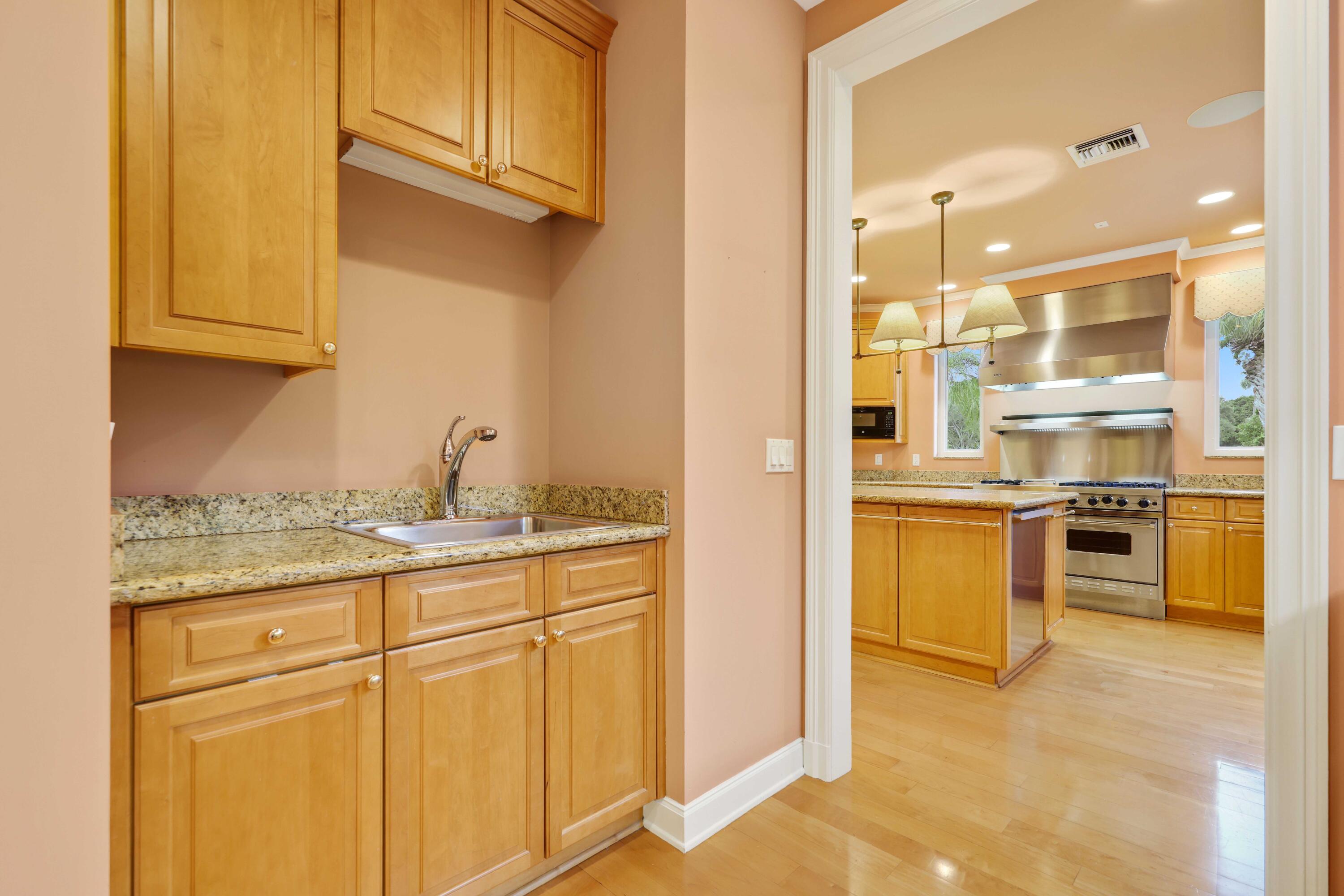 5 Country Road East, Unit A Boynton Beach, FL 33436 - Photo 24 of 51 a kitchen with stainless steel appliances granite countertop a refrigerator and cabinets