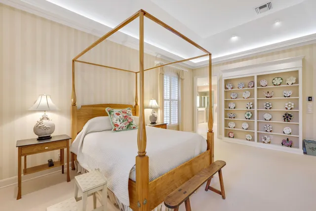 a bedroom with a bed a table and painting on the wall