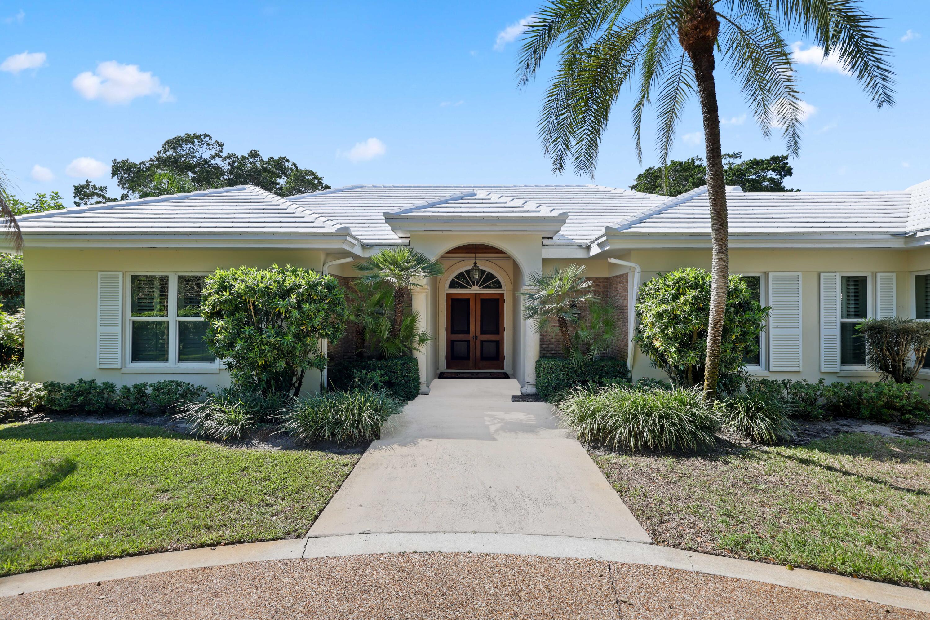 5 Country Road East, Unit A Boynton Beach, FL 33436 - Photo 3 of 51 a front view of a house with garden