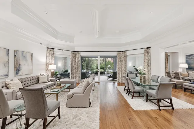 a living room with furniture large windows and wooden floor