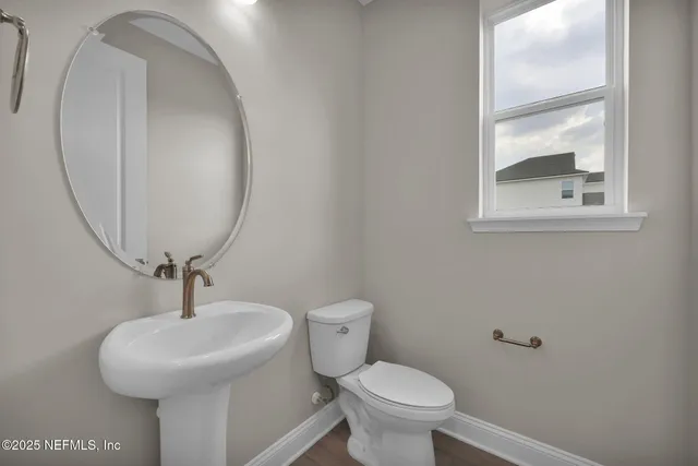 a bathroom with a toilet a sink and mirror