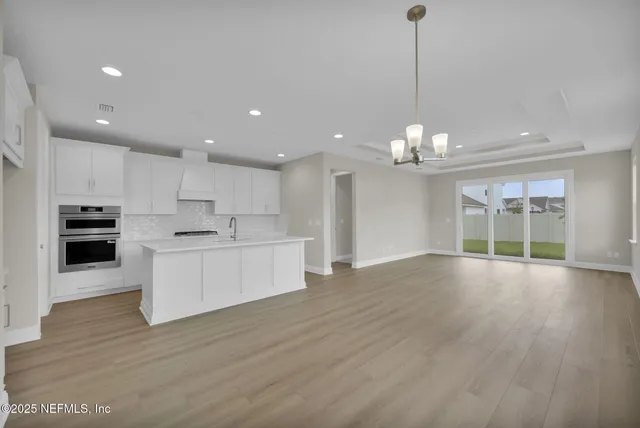 a view of kitchen with granite countertop cabinets and wooden floor