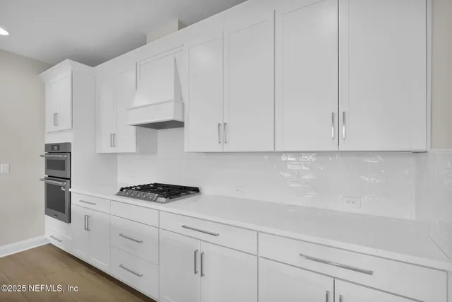 a kitchen with white cabinets and appliances