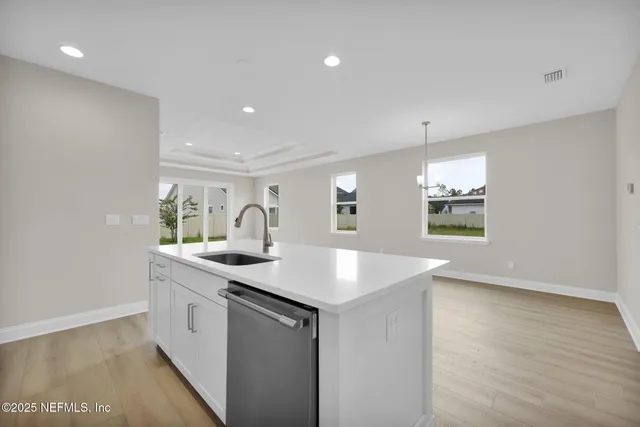 a kitchen with a sink and a stove with wooden floor