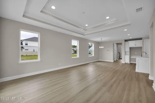 an empty room with windows and wooden floor