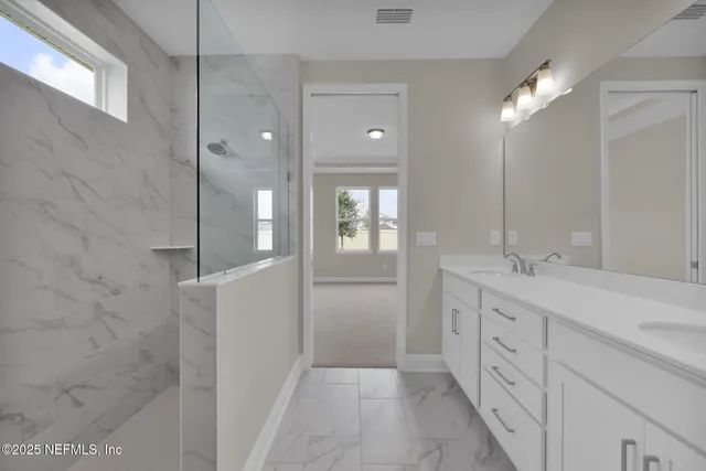 a bathroom with a double vanity sink a toilet and shower