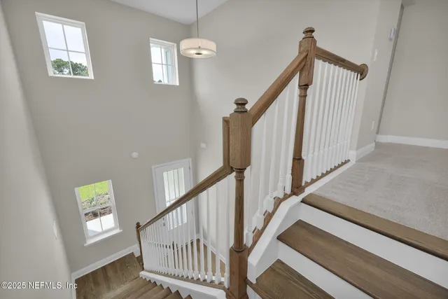 a view of staircase with wooden floor and white walls