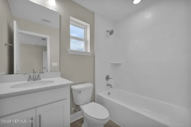 a bathroom with a toilet a sink a tub and mirror