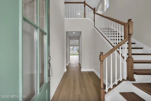a view of staircase with wooden floor and a chandelier