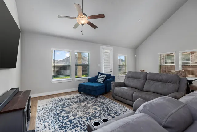 a living room with furniture a flat screen tv and a window