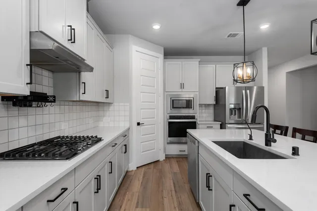 a kitchen with stainless steel appliances a sink stove and refrigerator