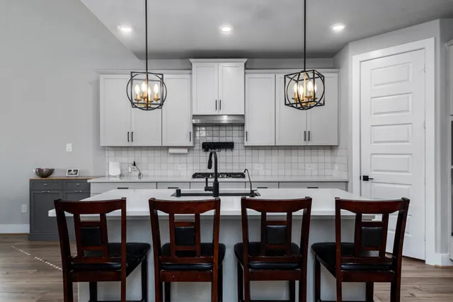 a kitchen with cabinets and chairs
