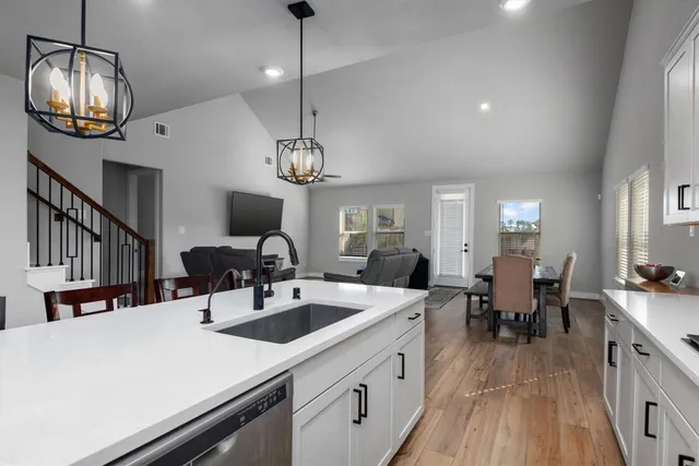 a view of a dining room with furniture a chandelier and wooden floor