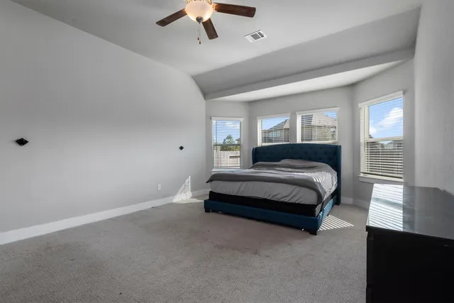 a spacious bedroom with a bed and a chandelier