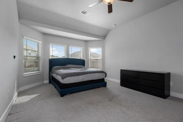 a spacious bedroom with a bed and window