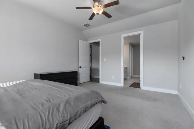 a bedroom with a large bed and a ceiling fan