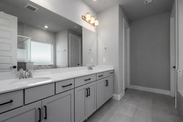 a bathroom with a double vanity sink and a mirror