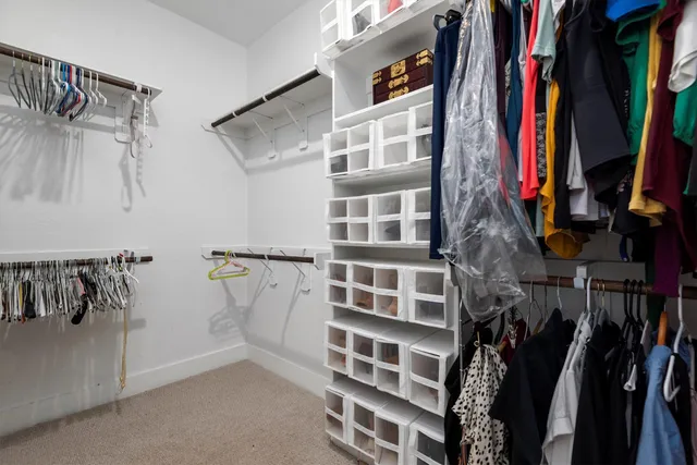 a view of walk in closet with clothes