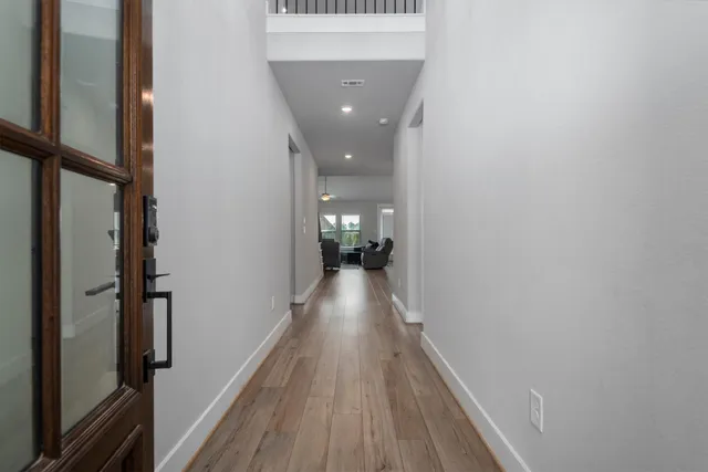 a view of a hallway with wooden floor