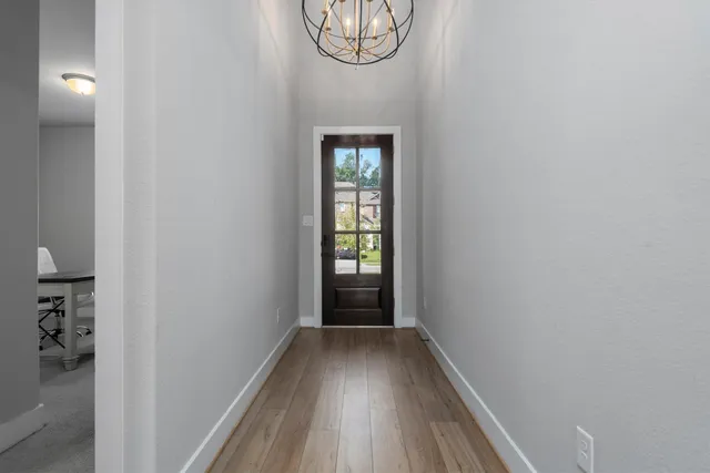 a view of a hallway with wooden floor and a potted plant
