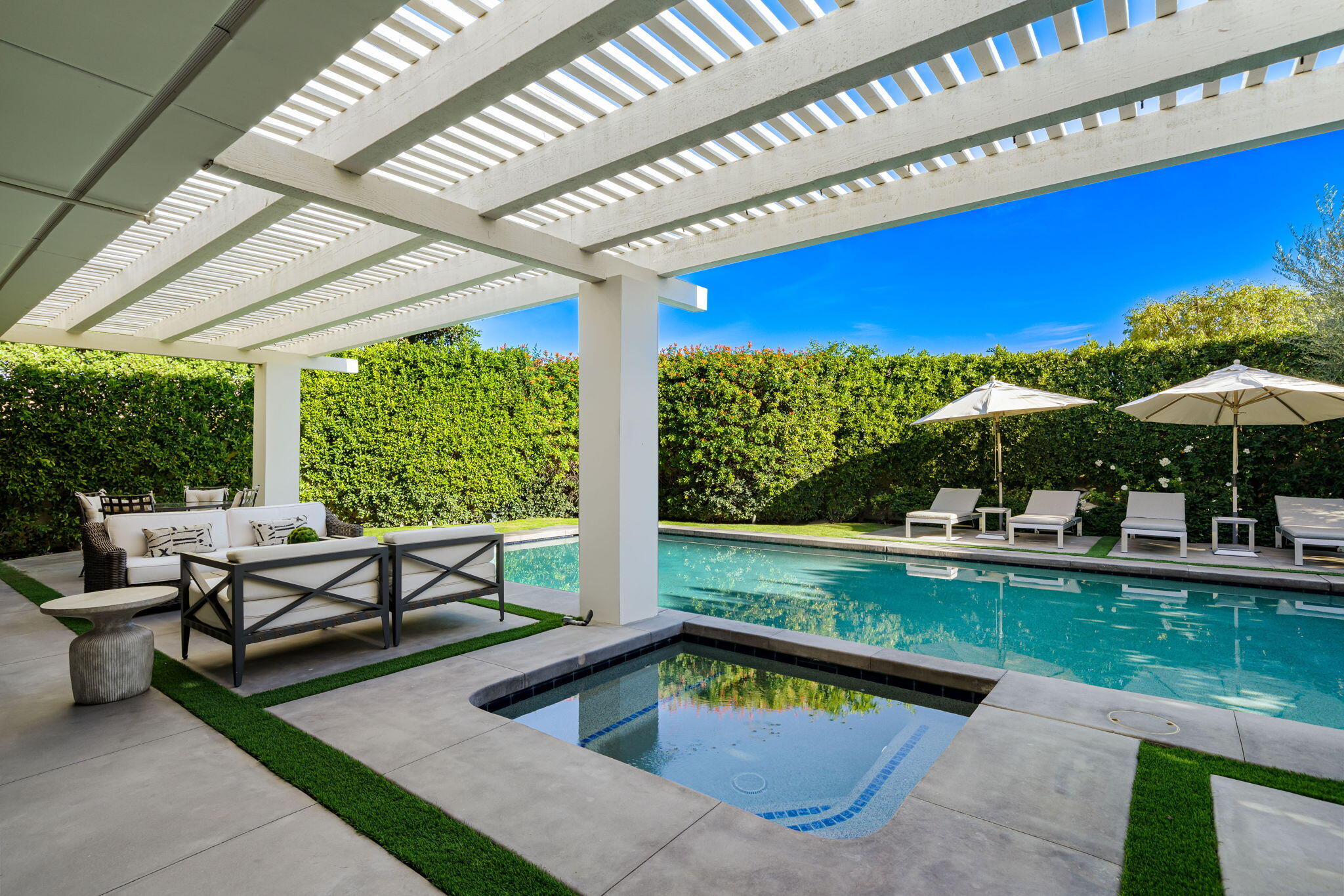 6 Exeter Court Rancho Mirage, CA 92270 - Photo 26 of 54 a view of swimming pool with a table and chairs under an umbrella