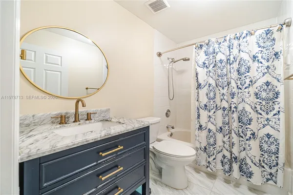 a bathroom with a granite countertop sink a toilet and a mirror