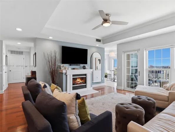 a living room with furniture a large window and a kitchen view