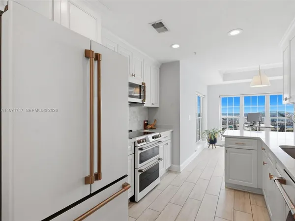 a kitchen with stainless steel appliances a refrigerator a stove top oven a sink and cabinets