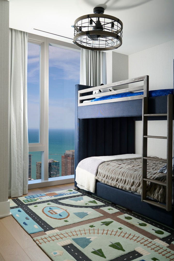 363 East Wacker Drive, Unit 6106 Chicago, IL 60601 - Photo 29 of 48 a bedroom with a bed and a chandelier