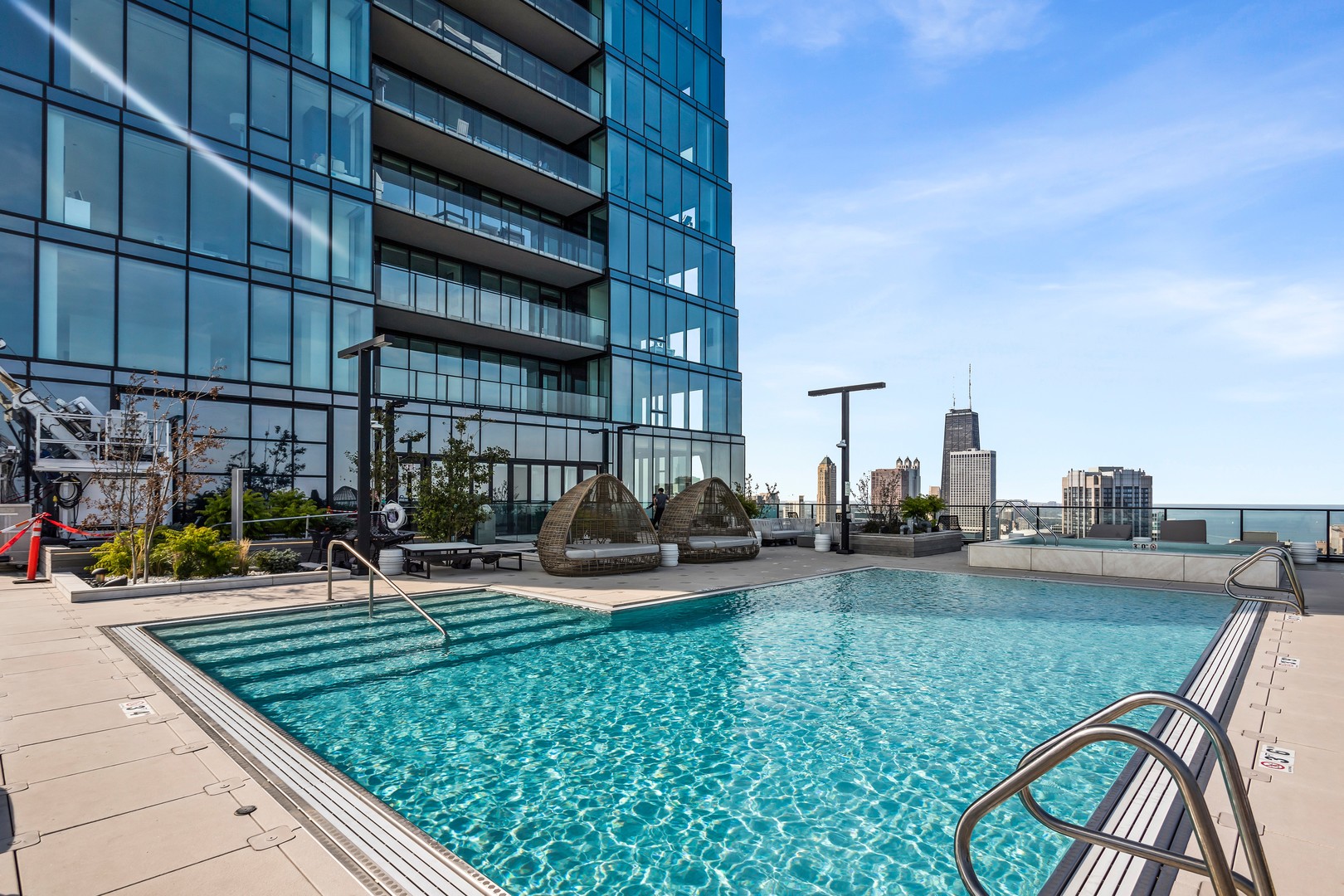 363 East Wacker Drive, Unit 6106 Chicago, IL 60601 - Photo 35 of 48 a view of a swimming pool with lawn chairs and a couch