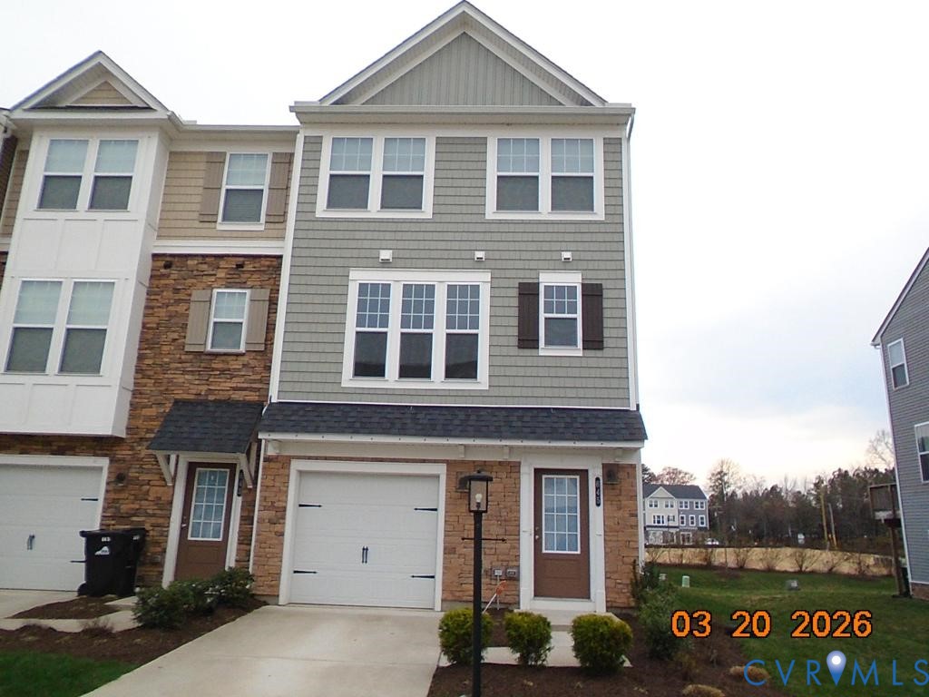 Craftsman house featuring stone siding, driveway,