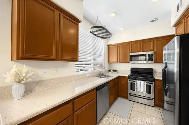 a kitchen with stainless steel appliances wooden cabinets a sink and a stove
