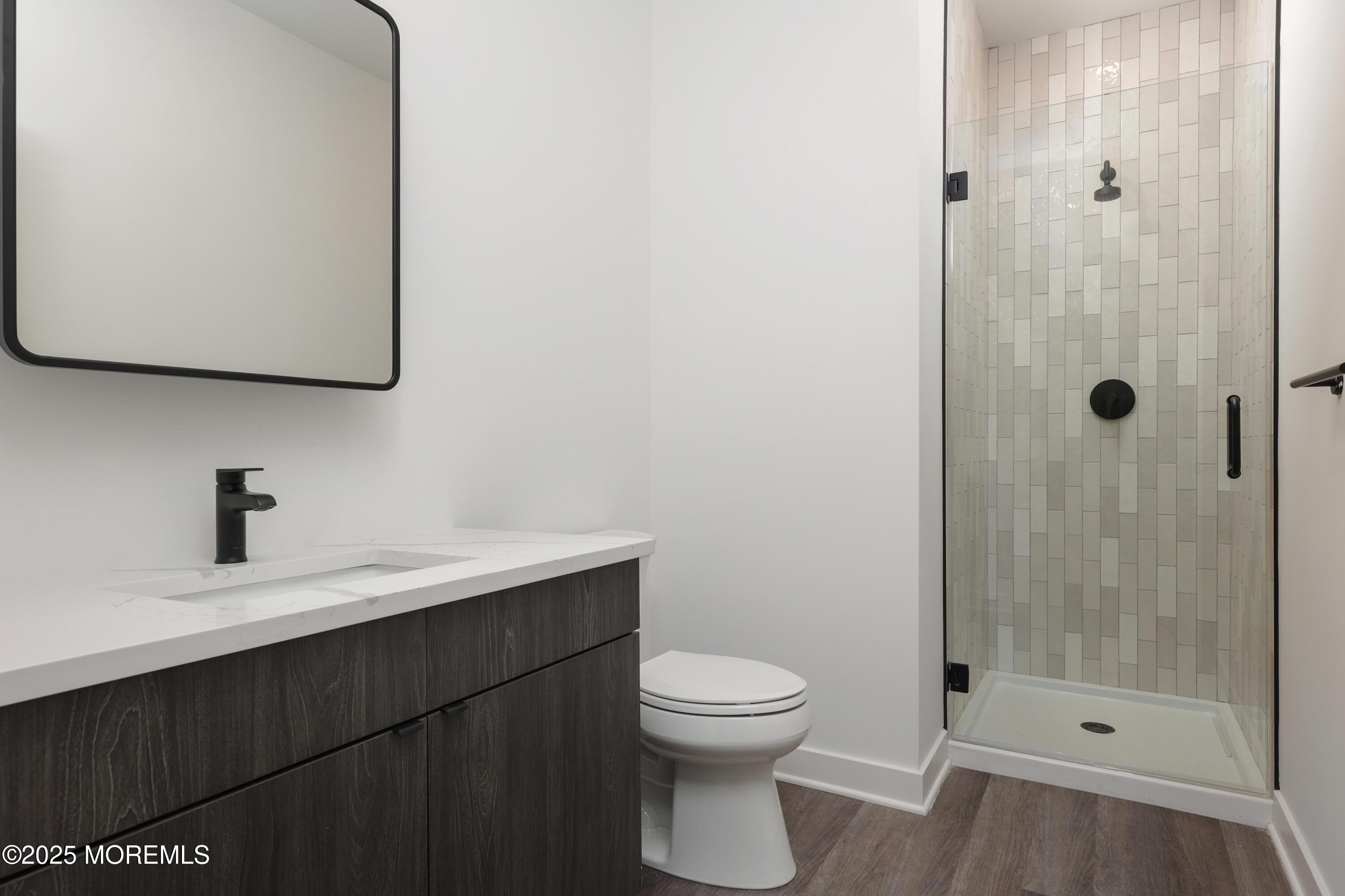 6 End Court, Unit 207 Long Branch, NJ 07740 - Photo 4 of 8 a bathroom with a sink a toilet and a mirror
