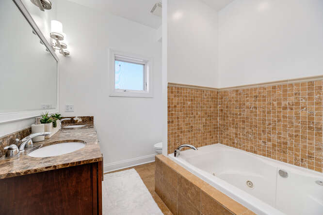 2118 West Rice Street, Unit 2 Chicago, IL 60622 - Photo 14 of 22 a bathroom with a granite countertop sink and a bathtub