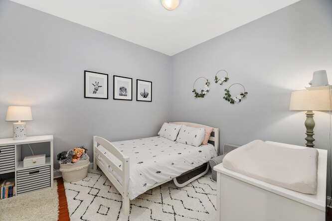 2118 West Rice Street, Unit 2 Chicago, IL 60622 - Photo 18 of 22 a bedroom with a bed and a lamp on dresser