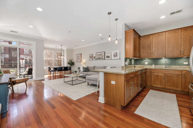 2118 West Rice Street, Unit 2 Chicago, IL 60622 - Photo 6 of 22 a kitchen with stainless steel appliances granite countertop wooden cabinets a sink dishwasher a stove and a refrigerator with wooden floor
