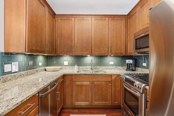 2118 West Rice Street, Unit 2 Chicago, IL 60622 - Photo 7 of 22 a kitchen with granite countertop a sink a stove and cabinets